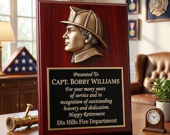 Könnte beinhalten: Eine rechteckige Holzplakette mit dunkelkirschfarbenem Finish und einem bronzefarbenen Relief eines Feuerwehrmanns mit Helm. Eine schwarze Platte trägt den Text: Presented To CAPT. BOBBY WILLIAMS For your many years of service and in recognition of outstanding bravery and dedication. Happy Retirement Dix Hills Fire Department.