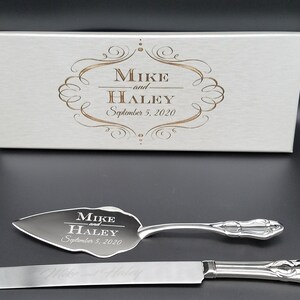 May include: A silver cake knife and server set in a white box. The box is engraved with "Mike and Haley September 5, 2020". The knife and server are also engraved with "Mike and Haley September 5, 2020".
