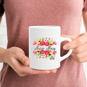 May include: White ceramic mug with a floral design and the text "Nurse Mary RN".