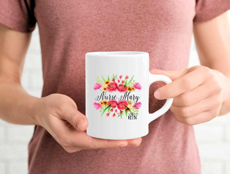 May include: White ceramic mug with a floral design and the text "Nurse Mary RN".