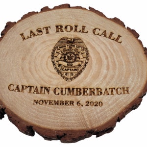 May include: A wooden plaque with the words "Last Roll Call" and "Captain Cumberbatch" engraved on it. The plaque also features a badge with the words "New York City Correction" and "Captain" engraved on it. The date "November 6, 2020" is also engraved on the plaque.