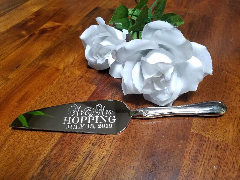 May include: Silver cake server with the inscription "Mr. & Mrs. Hopping, July 13, 2019" engraved on the blade.