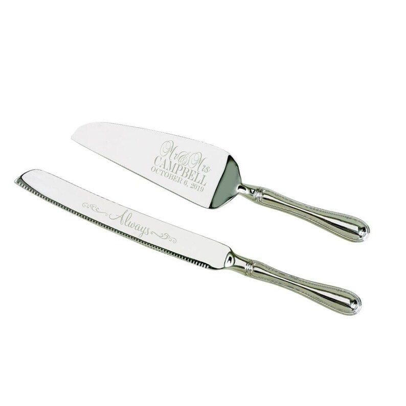 May include: A silver cake knife and server set with engraved text. The server has the text "Mr. & Mrs. Campbell October 6, 2019". The knife has the text "Always" engraved on the blade.