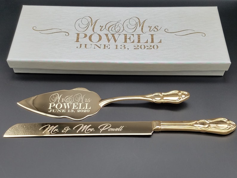 May include: Gold-toned cake knife and server set with engraved text "Mr & Mrs Powell June 13, 2020" and "Mr. & Mrs. Powell".