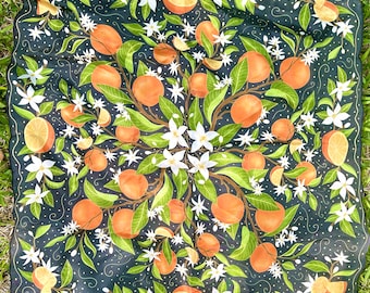 May include: A black silk scarf with a repeating pattern of white blossoms and orange citrus fruit. The design is centered and symmetrical.