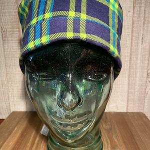 May include: A navy blue and lime green plaid beanie hat. The hat is made of a soft, comfortable fabric and has a relaxed fit.