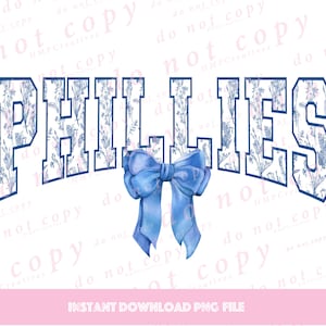 May include: A blue and white floral design with the word "PHILLIES" in a navy blue outline. A blue bow is centred below the word.