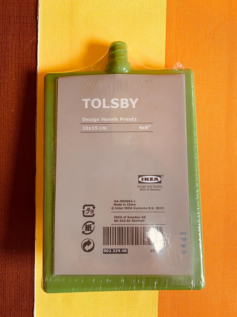 May include: Green plastic cutting board with the text "TOLSBY" and "Design Henrik Preutz" printed on it. The board measures 10x15 cm or 4x6 inches. The back of the board has a barcode and the text "AA-905664-1 Made in China Inter IKEA Systems B.V. 2013 IKEA of Sweden AB SE-343 81 &Auml;lmhult 002.329.48".
