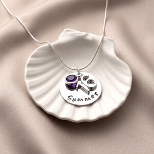 A personalised 16th birthday necklace gift laid on a ceramic shell