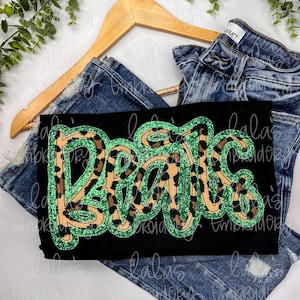 May include: Black t-shirt with the word "Roar" in green and brown glitter letters. The letters are outlined in green and have a leopard print pattern.