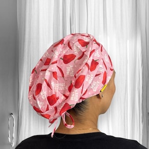 May include: Pink surgical scrub hat with a red chili pepper print and the text "Hot Stuff You" repeated throughout.