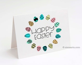 May include: A white card with a circle of colorful Easter eggs around the words "Happy Easter".
