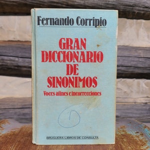 May include: A blue book with the title "Gran Diccionario de Sinonimos" by Fernando Corripio. The book is published by Bruguera-Libros de Consulta and features the text "Voces afines e incorrecciones".