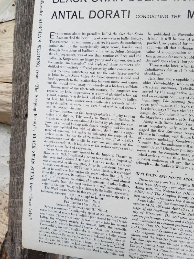 May include: A black and white newspaper article about the ballet Swan Lake, featuring a photo of conductor Antal Dorati. The article discusses the history of the ballet, the music, and the choreography. The text includes the title "Antal Dorati Conducting The Music Of Tchaikovsky's Swan Lake" and the subheading "Hi-Fi Facts and Notes About The Sleeping Beauty and Swan Lake".