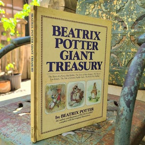 May include: A vintage "Beatrix Potter Giant Treasury" book with a cream-colored cover and blue text. The book features illustrations and the author's name. The spine reads "Beatrix Potter Giant Treasury".