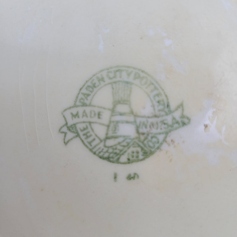 May include: Green and white logo on a white background. The logo reads "The Padden City Potteries Made in U.S.A."