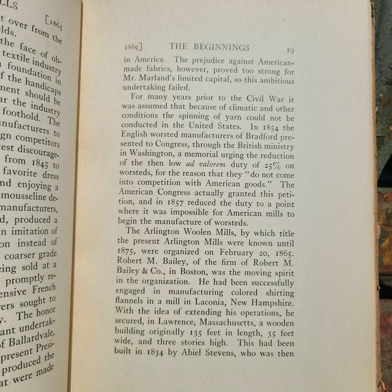 May include: A page from a book about the history of the American textile industry. The text discusses the challenges faced by early American textile manufacturers in competing with British manufacturers. The text mentions the Arlington Woolen Mills, which were founded in 1865 in Lawrence, Massachusetts.