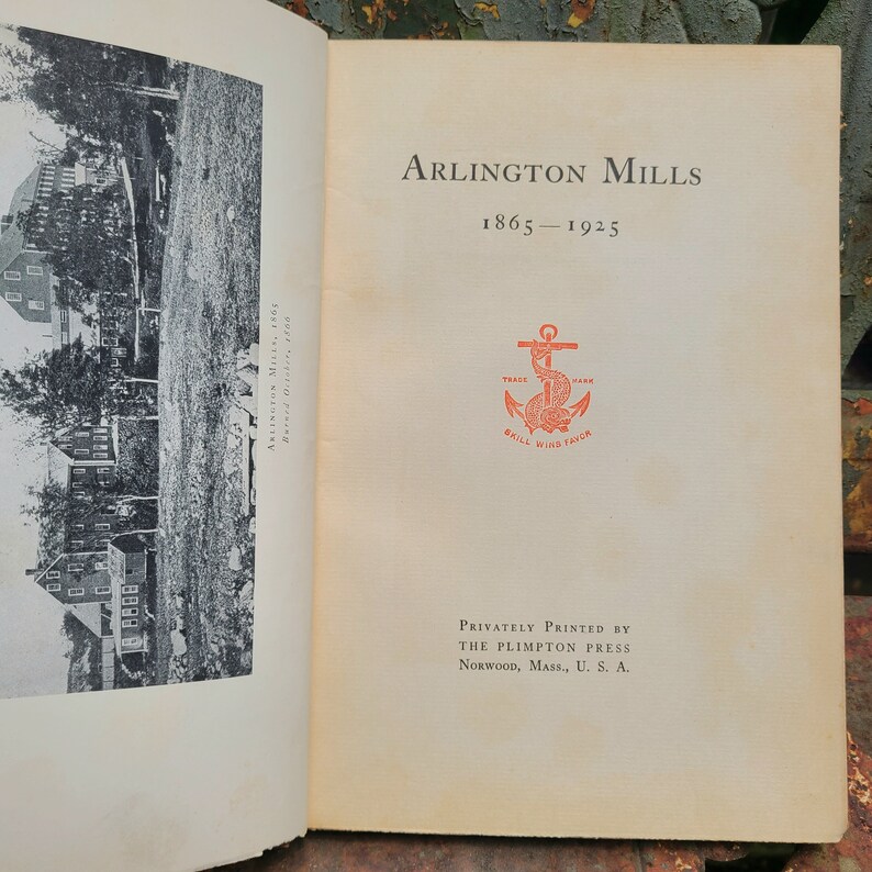 May include: A black and white photo of a building with the text "Arlington Mills 1865-1925" and a red anchor with the text "Trade Mark Skill Wins Trick" printed on a white page.