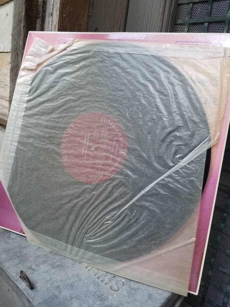May include: A black vinyl record in a pink and white paper sleeve. The record has a red label with the text "High Fidelity" and "EMI" on it.