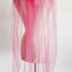 May include: A pink tulle bridal veil on a mannequin.