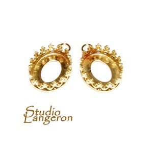 May include: Two gold-tone oval-shaped pendant settings with a crown-like border. The settings are designed to hold a stone or other embellishment.