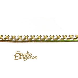 Puede incluir: Moldura de metal dorado con un borde festoneado decorativo. La moldura tiene aproximadamente 1,25 cm de ancho.