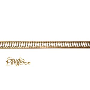 Puede incluir: Moldura de metal dorado con un patrón repetitivo de círculos y óvalos conectados.