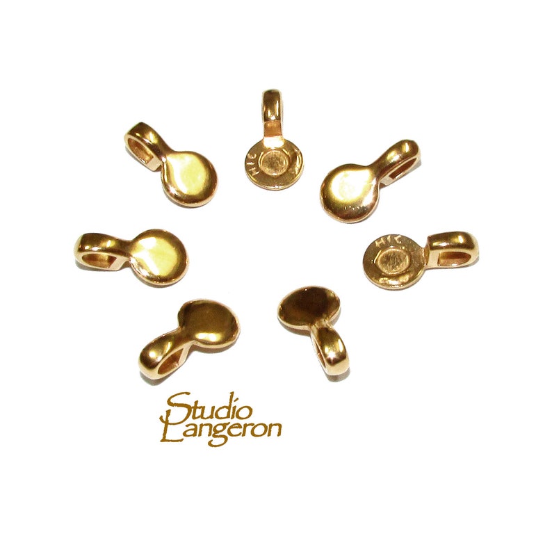 May include: Eight gold-toned metal pendant bails with a loop at the top and a flat circular base.