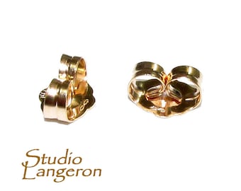 May include: Two gold-toned earring backs. The backs are shaped like a heart with a small loop on the top.