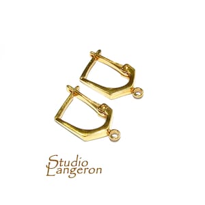 May include: Two gold-toned earring hooks with a hinged closure. The hooks are made of metal and have a smooth finish.