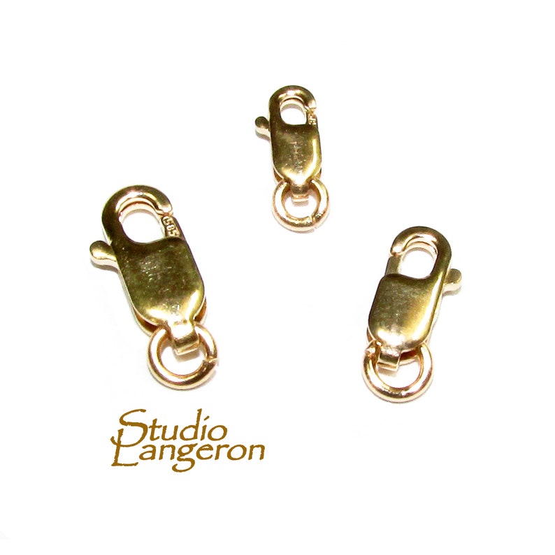 May include: Three gold-toned lobster claw clasps with a ring on the end. The clasps are a common jewelry finding used for necklaces, bracelets, and other jewelry.