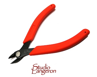 Puede incluir: Alicates de corte con mangos rojos y cuchillas negras. Los mangos son curvos y ergonómicos. Hay un pequeño agujero en el extremo de cada mango. El texto "Xuron" es visible en un mango. Herramienta de corte de precisión.