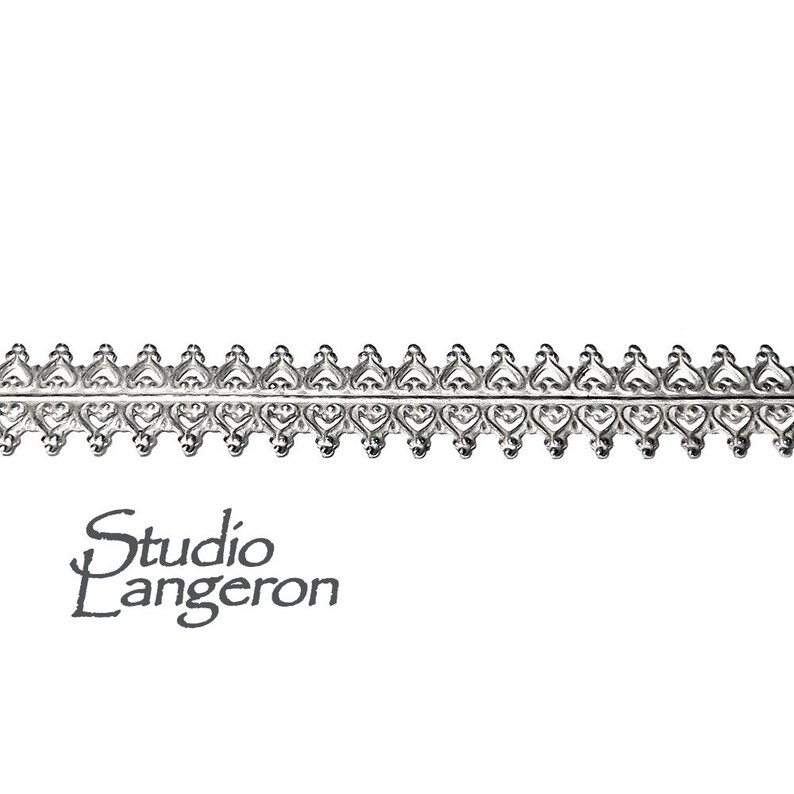 Peut inclure: Garniture en m&eacute;tal argent&eacute; avec un motif de c&oelig;ur r&eacute;p&eacute;t&eacute;. La garniture mesure environ 1,2 cm de large.