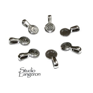 May include: Silver-toned metal pendant bails with a decorative eye design. The bails are round and have a loop at the top for attaching a chain or cord.