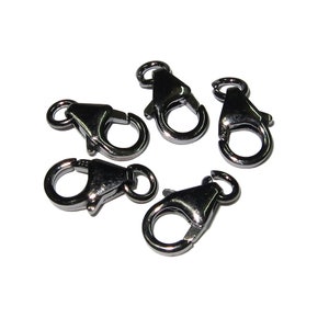 May include: Five dark gray metal lobster clasps arranged on a white background. Each clasp has a spring-loaded gate and a small loop for attaching to jewelry or other items. The clasps are made of a shiny, metallic material.