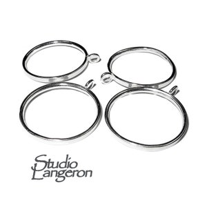 May include: Four silver metal round pendant frames with a small loop at the top.