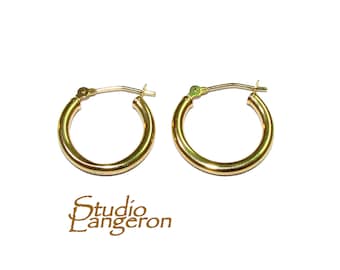 May include: A pair of gold hoop earrings. The earrings are simple and classic, with a smooth, polished finish.