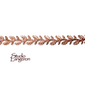 May include: A copper-colored metal chain with a repeating pattern of oak leaves and acorns. The chain is on a white background.