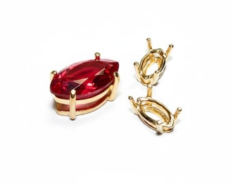 May include: A marquise-cut, deep red gemstone set in a gold-colored metal setting. Next to it are two gold-colored metal settings, designed to hold gemstones. The text "Studio Langeron" is at the bottom of the image.