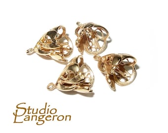 May include: Four gold-colored metal decorative end caps with intricate designs. The end caps are open on one side and have a small loop on the other side.