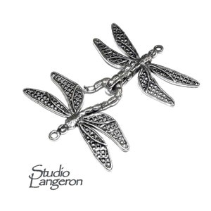 May include: Two silver dragonfly charms with intricate details and openwork designs. Each charm has a loop for attaching to jewelry or other crafts.