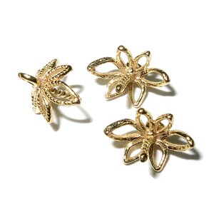 May include: Three gold-colored metal flower-shaped bead caps with a hole in the center for stringing.