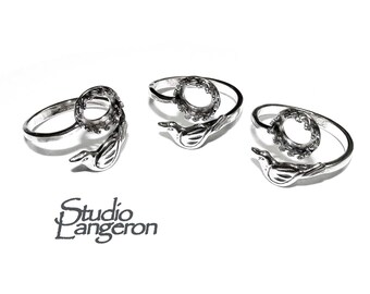 May include: Three silver adjustable rings with a bird design and a round bezel setting. The rings are made of metal and have a polished finish.