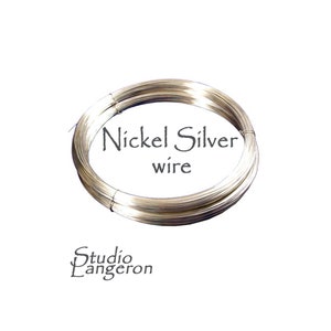 Puede incluir: Un rollo de alambre de plata de níquel de color plateado. El alambre está enrollado en un círculo y el texto "Nickel Silver wire" está impreso en el rollo.