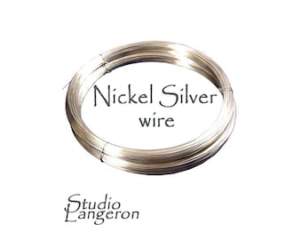 Puede incluir: Un rollo de alambre de plata de níquel de color plateado. El alambre está enrollado en un círculo y el texto "Nickel Silver wire" está impreso en el rollo.