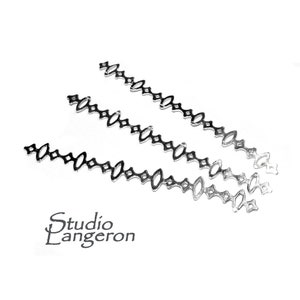 May include: Three silver metal chains with a repeating pattern of small diamonds and ovals. The chains are arranged in a fan shape on a white background. Studio Langeron is printed in black text below the chains.