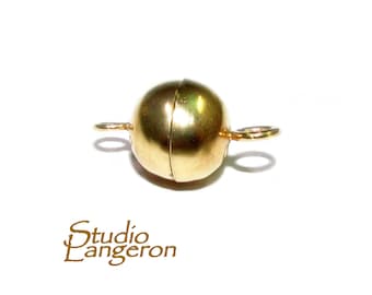 May include: Gold magnetic clasp for jewelry making. The clasp is a round ball with two loops on either side.