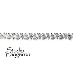 May include: Silver-toned metal trim with a repeating pattern of stylized oak leaves.