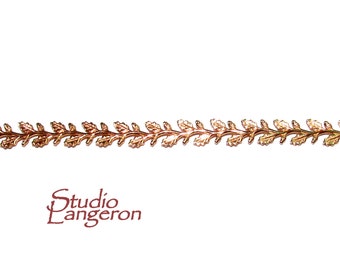 May include: A gold-toned metal trim with a leaf design. The trim is made of two different shades of gold, creating a subtle contrast.