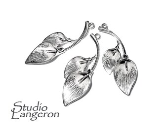 May include: Silver-toned leaf charms with detailed veining and a loop for jewelry making. The charms are arranged on a white background. The Studio Langeron logo is visible in the lower left corner.